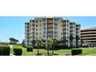 Beautiful condo building with multiple balconies surrounded by lush landscaping and palm trees at 4670 Links Village Dr # A506, Ponce Inlet, FL 32127