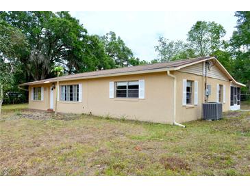 A single story home with a tan facade, white trimmed windows, and an open yard at 522 Grace Ave, Deland, FL 32724