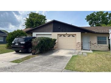 Charming single-story home featuring a one car garage, well-kept lawn, and tidy front landscaping at 908 Boulder Dr, South Daytona, FL 32119