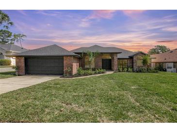 Charming brick home with a well-manicured lawn and professional landscaping, with an attached two-car garage at 104 Balmoral Ct, Debary, FL 32713