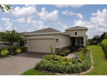 Charming single-story home with a brick driveway, well manicured lawn and colorful landscaping at 1118 Avery Meadows Way, Deland, FL 32724