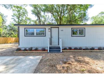 Charming home with manicured flowerbeds flanking the entry at 165 S Massachusetts Ave, Deland, FL 32724