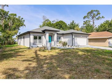 Charming single-story home featuring a well-maintained lawn and an attached two-car garage at 1738 Palm Rd, Ormond Beach, FL 32174