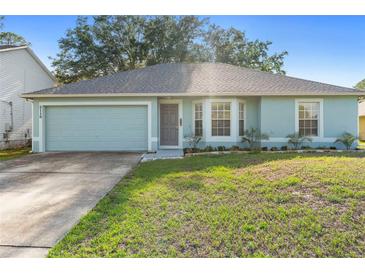 Charming single-story home with a well-maintained lawn and a two-car garage at 2110 3Rd Ave, Deland, FL 32724