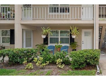 Condo with cozy front patio featuring blue chairs, lush landscaping, and hanging plants at 2500 Lee Rd # 134, Winter Park, FL 32789