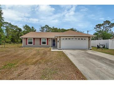 Charming single-story home with a two car garage and red shutters, surrounded by trees at 3001 Inca Ct, Deltona, FL 32738