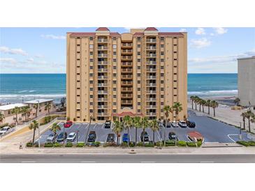 Oceanfront condo building with a parking lot lined with palm trees and direct beach access at 3145 S Atlantic Ave # 503, Daytona Beach Shores, FL 32118