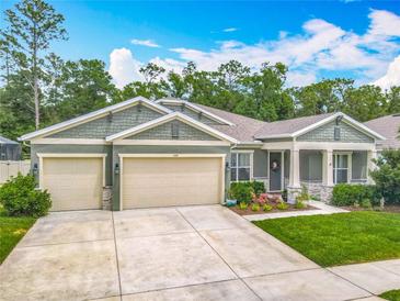 Charming single-story home with a manicured lawn, featuring a two-car garage and inviting front porch at 409 Nowell Loop, Deland, FL 32724