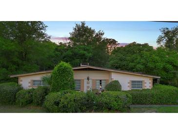 Charming single-story home with lush landscaping and a neatly maintained yard at 409 S Sparkman Ave, Orange City, FL 32763