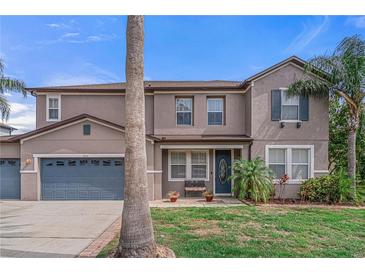 Charming two-story home with well-manicured lawn, mature palms, and a welcoming front porch at 4604 Barbados Loop, Clermont, FL 34711