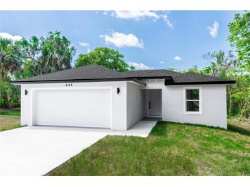 Charming single-story home with a two-car garage, fresh landscaping, and a well-manicured lawn at 544 E Voorhis Ave, Deland, FL 32724