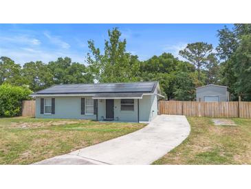 Charming single-story home featuring a well-maintained lawn, solar panels, and a long driveway at 6509 Lake Lerla Dr, Apopka, FL 32712