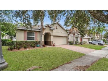 Charming single Gathering house featuring tan siding, arched doorway, and manicured lawn at 680 Preakness Cir, Deland, FL 32724