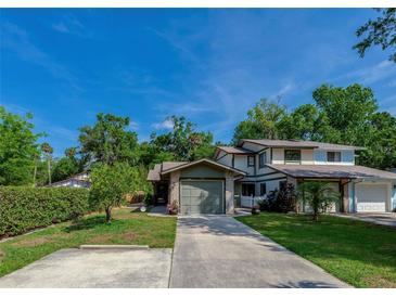 Charming two-story home with a well-maintained lawn, lush landscaping, and a concrete driveway at 834 Sugar House Dr, Port Orange, FL 32129