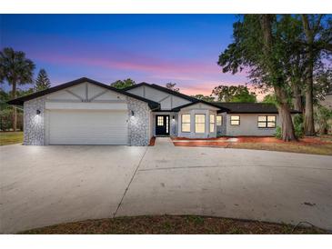 Charming single-story home boasts a manicured lawn, well-lit facade, and attached two-car garage at 9720 Fairway Cir, Leesburg, FL 34788