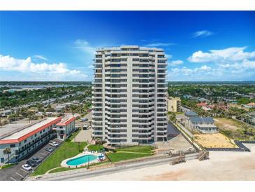 Stunning aerial view of oceanfront condo tower with pool and beach access under sunny sky at 1420 N Atlantic Ave # 202, Daytona Beach, FL 32118
