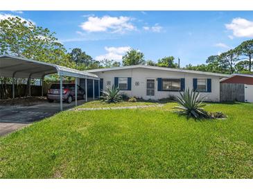 Charming single-story home featuring a carport, lush lawn, and well-maintained landscaping at 1608 Raleigh Ave, Daytona Beach, FL 32117