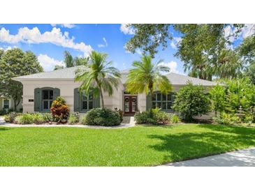 Charming home with lush landscaping, palm trees, and well-manicured lawn at 1653 Promenade Cir, Port Orange, FL 32129