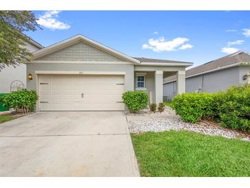 Charming single-story home featuring a two-car garage, well-manicured lawn, and welcoming curb appeal at 211 Duke Dr, Deland, FL 32724