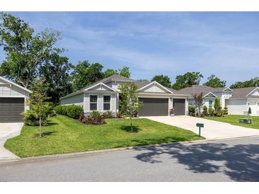 Charming single-story home with a well-manicured lawn, two-car garage, and beautifully landscaped front yard at 3026 Adrian Dr, Ormond Beach, FL 32174