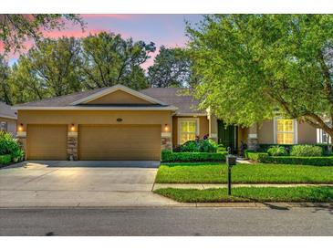 Charming home featuring a three-car garage, manicured lawn, and decorative stone accents at 320 W Victoria Trails Blvd, Deland, FL 32724