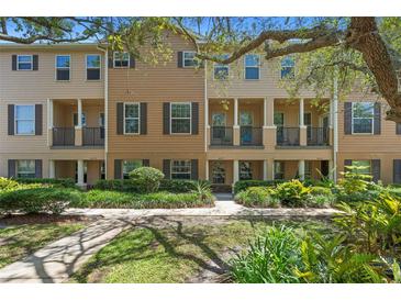 Inviting townhouse featuring a well-maintained lawn, dark shutters, and a covered front porch at 4297 Regal Town Ln, Lake Mary, FL 32746