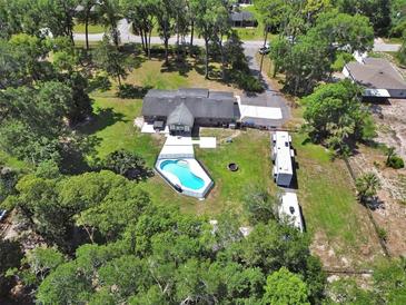 Aerial shot highlighting a pool, RV parking, spacious backyard, and peaceful surroundings at 851 W Wisconsin Ave, Orange City, FL 32763
