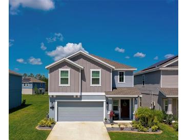 Charming two-story home with gray siding, a well-manicured lawn and inviting front entrance at 1183 Cabot Cliffs Dr, Daytona Beach, FL 32124
