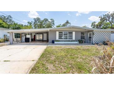 Charming single-story home with a gray exterior, carport, and well-maintained front yard at 1284 Vanderbilt Dr, Ormond Beach, FL 32174