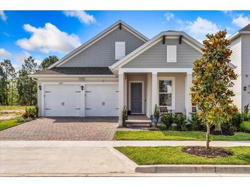 Charming home featuring a two-car garage, brick pathway, and a welcoming covered front porch at 16241 Honey Harvest St, Winter Garden, FL 34787