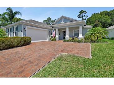 Charming single-story home with a brick driveway, manicured lawn, and a welcoming front porch at 171 Birchmont Dr, Deland, FL 32724