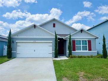 Charming single-Gathering home with manicured lawn, two-car garage, red shutters, and stylish curb appeal at 1759 Copinger Ter, Kissimmee, FL 34744