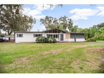 Charming single-story home with well-maintained lawn, mature trees, and neutral color palette at 2215 Lake Ruby Rd, Deland, FL 32724
