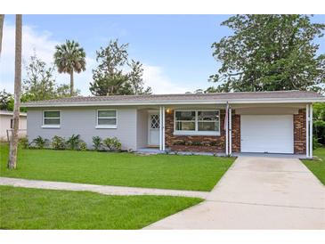 Charming single-story home boasts a well-manicured lawn, brick accents, and an attached carport at 2226 Sherwood Dr, South Daytona, FL 32119
