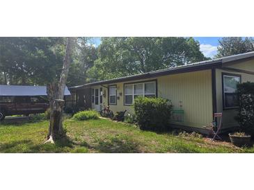 Charming single-story home with a well-maintained lawn and cozy front porch at 27751 Luella Ave, Paisley, FL 32767