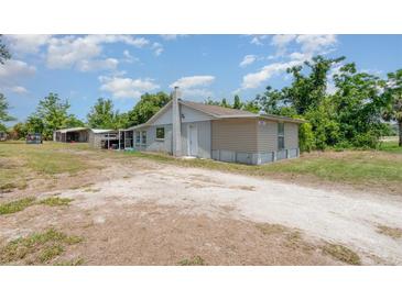 Charming single-story home featuring a gravel driveway and well-lit, welcoming entrance at 32811 County Road 473, Leesburg, FL 34788