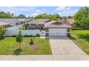 Charming single-story home featuring a two-car garage, well-manicured lawn, and white picket fence at 5478 Landis Ave, Port Orange, FL 32127