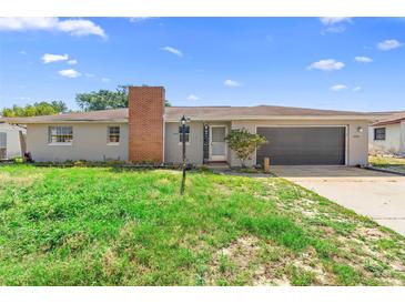 Charming single-story home featuring an attached garage and brick chimney, perfect for comfortable living at 1483 Meadowlark Dr, Deltona, FL 32725