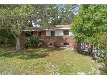 Charming brick two-story home with a well-maintained front yard and mature trees at 2032 Yorkshire Dr, Deland, FL 32724
