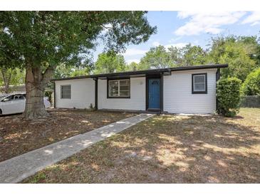 Charming single-story home featuring a blue front door, white siding, and mature landscaping at 2434 Barbarossa Ave, Deltona, FL 32738