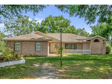 Charming brick home features a well-manicured lawn and inviting front entrance at 2885 Newmark Dr, Deltona, FL 32738