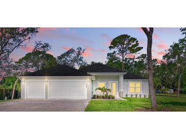 Charming single-story home featuring a three-car garage and lush landscaping, perfect for suburban living at 2894 Hardy Ave, New Smyrna Beach, FL 32168
