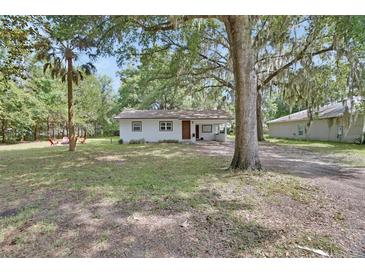 Charming single-story home with a well-maintained front yard and mature trees at 352 Harlan Ave, Lake Helen, FL 32744