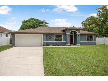 Charming single-story home featuring a two-car garage, well-maintained lawn, and inviting curb appeal at 37 Naranja Rd, Debary, FL 32713