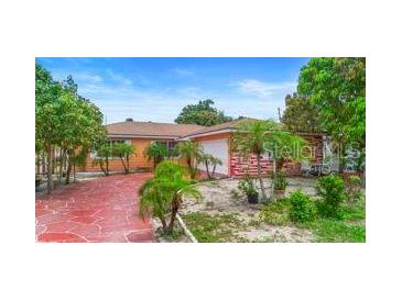 Single-story home featuring a red, paved driveway and tropical landscaping at 558 Tulane Dr, Altamonte Springs, FL 32714
