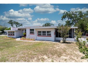 Charming single-story home with white exterior and red trim, surrounded by a well-manicured lawn at 601 Berkshire Rd, Daytona Beach, FL 32114