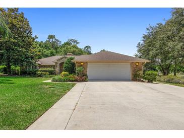 Charming single-story brick home with a spacious two-car garage and well-manicured lawn at 980 Marjorie Rawlings Dr, Deland, FL 32720