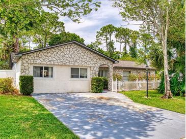 Charming one-story home with a stone exterior and a well-maintained front yard with a concrete driveway at 1229 Jeffery Dr, Port Orange, FL 32129