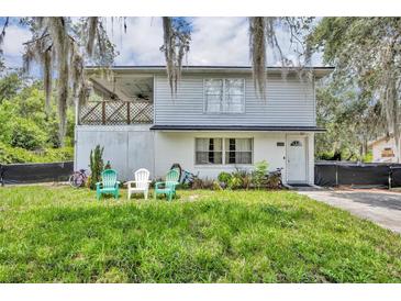 Two story home with a balcony, landscaped lawn, and outdoor seating in the front yard at 1398 5Th Ave, Deland, FL 32724