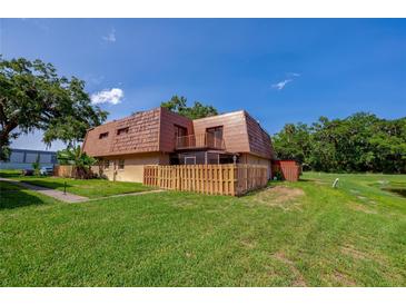 A charming home featuring a unique roofline, fenced yard, and lush green lawn at 152 Sweetgum Ln, Port Orange, FL 32129